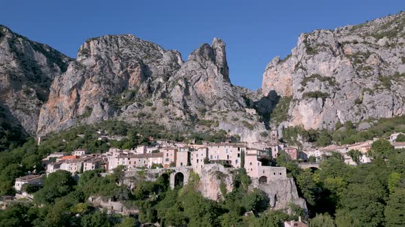 Huge limestone cliffs and Moustiers-Sainte-Marie village in France - aerial shot