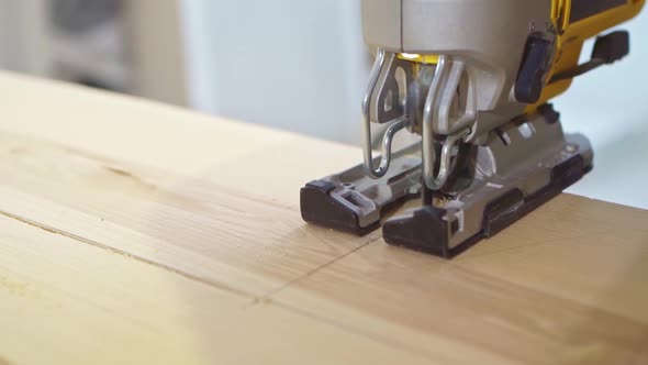 Carpenter Cuts Wood with Electric Jigsaw