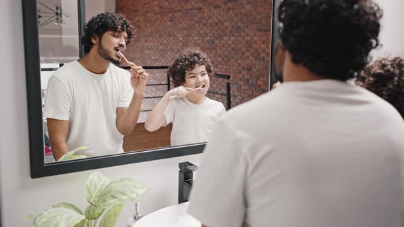 Indian Man and Biracial Brother Brush Teeth After Waking Up