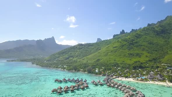 drone fly over tropical overwater bungalows in Polynesia tahiti mo'orea