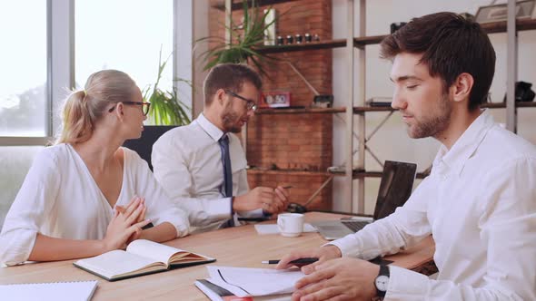 Succesful Caucasian Male Boss Sitting at Table with Female Secretary Giving His Card to Office Man