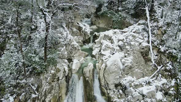 Waterfall Flowing From White Rocks Into a Lake in the Forest