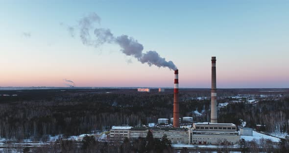 Thermal Power Plant with smoking chimneys in winter close-up. Ecology concept. Forest landscape