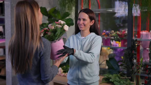 Smiling Seller Passing Bouquet to Buyer Crossing Hands in Slow Motion Looking at Camera