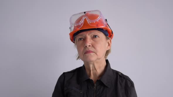 Expressive Woman in Safety Helmet Shouting Into Megaphone