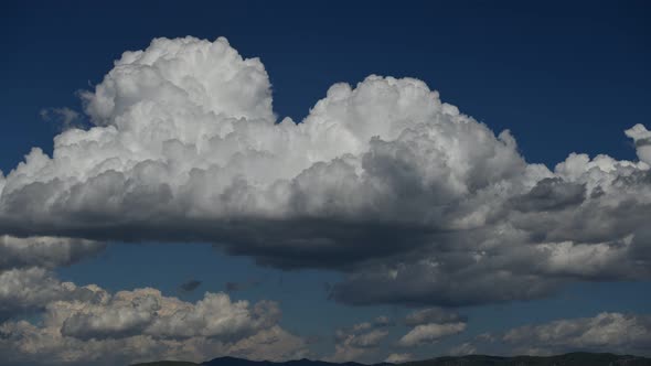 Time lapse of voluminous white clouds over blue sky