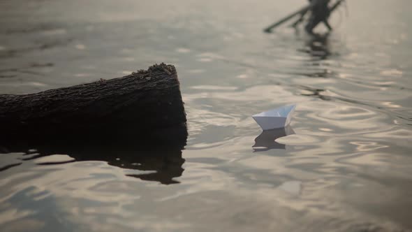 Paper Boat On River At Sunset. Origami Ship Sailing On Pond. Man Hand Launch Paper Boat On Water