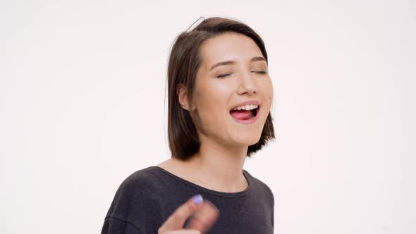 Portrait of Young Pretty Girl Clicking Finger and Winking