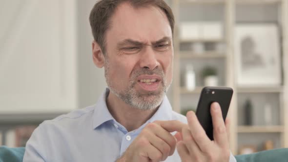 Senior Aged Businessman Reacting to Loss While Using Smartphone