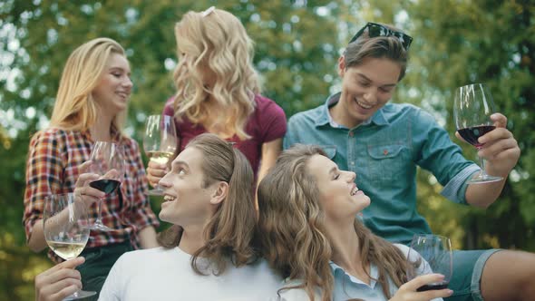 Friends Toasting With Drinks At Dinner Party Outdoors