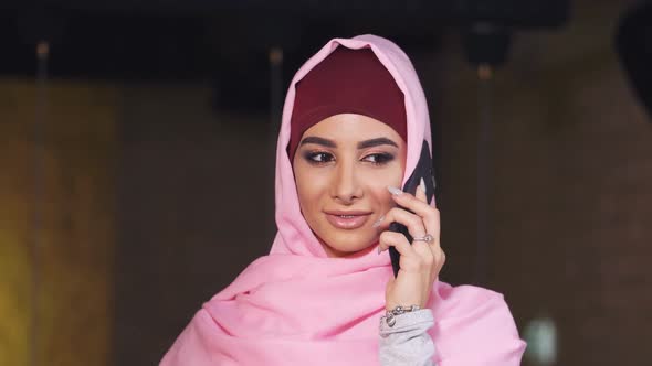 Modern Young Muslim Woman in Hijab Smiling Talking on Mobile Phone