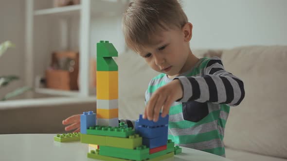Child Playing with Colorful Building Plastic Blocks Constructor at Home