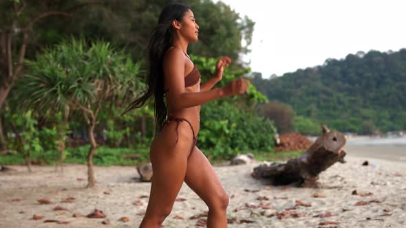 Beautiful Young Woman Walking Along Beach In Bikini