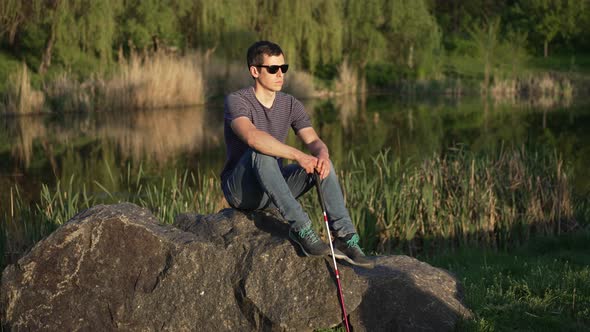 Blind Man with a Cane Sitting on the Rock