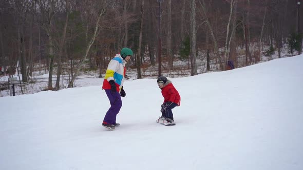 Young Man Snowboard Instructor Tiches Little Boy How To Ride a Snowboard, Winter Activities Concept