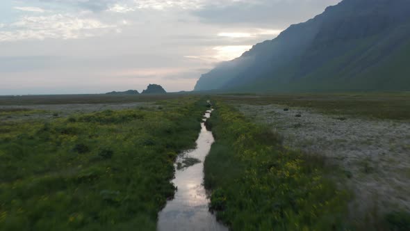 Birds Eye Drone Flying Over Small River in Green Highlands in Iceland