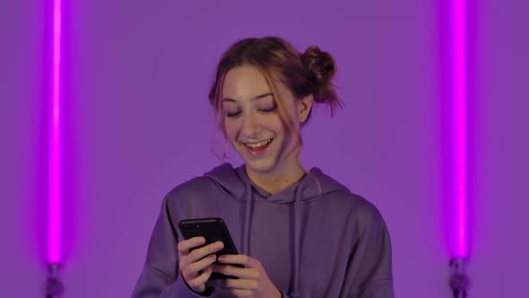 Portrait of Young Attractive Woman is Texting on Mobile and Rejoice