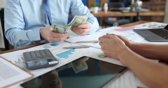 Cropped View of Successful Businessman Counting Money in Front of Manager