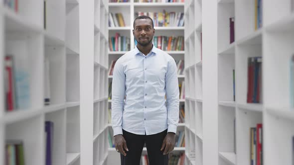 African American Man Portrait Smiling Looking at Camera Standing in Library