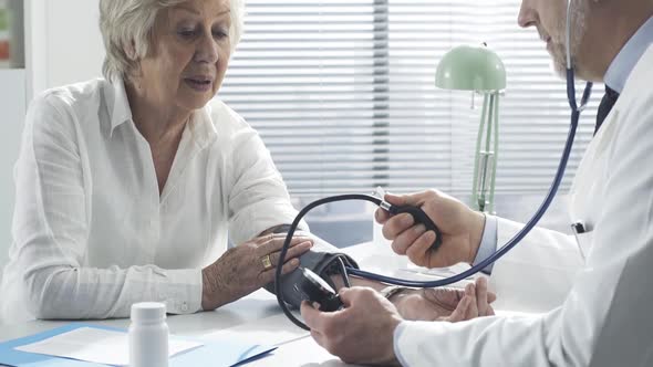 Doctor measuring blood pressure of a senior patient