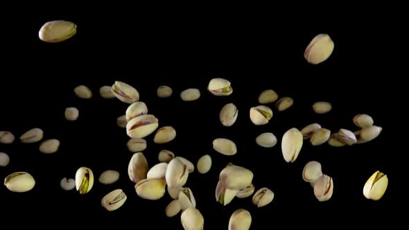 Green Pistachios Are Bounce on a Black Background