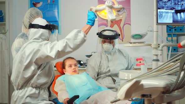 Dentist Technician in Coverall Drilling Kid Tooth in Dental Clinic