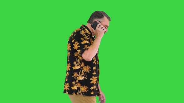 Caucasian Old Man Walking and Talking on the Phone on a Green Screen Chroma Key