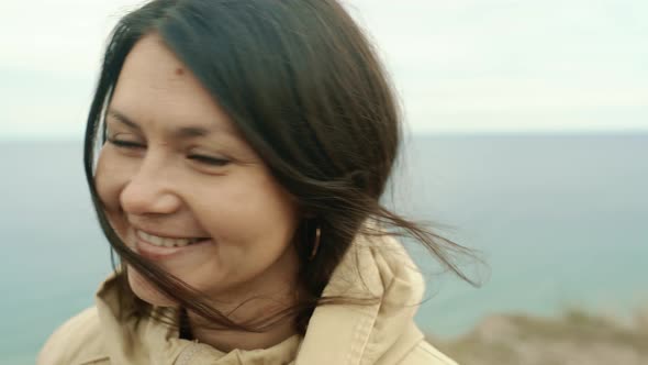 Portrait of a Brunette Girl Looking at the Camera on the Background of the Sea