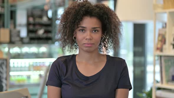 Portrait of Young African Woman with Thumbs Down Sign