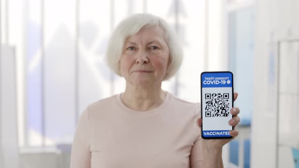 Mature Pensioner Female Person Showing Smartphone in Her Hand with Mobile Application for