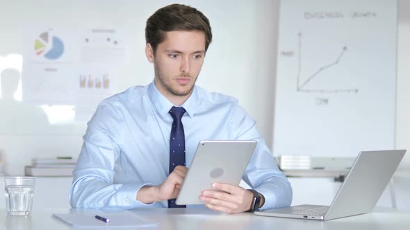 Young Businessman Using Tablet in Office