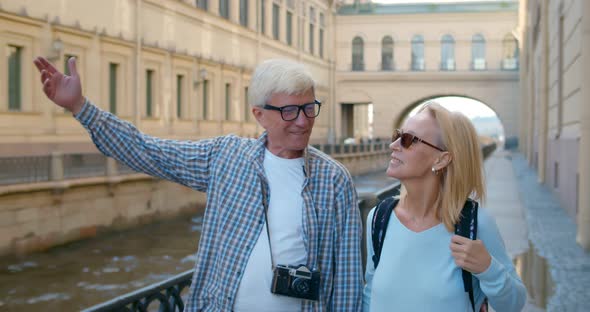 Mature Couple Walking on Street on Weekend Vacation Looking and Enjoying Architecture