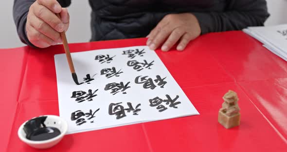 Man write chinese calligraphy for lunar new year