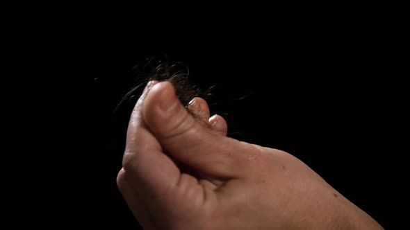 Detail of woman hand with hair loss on black background