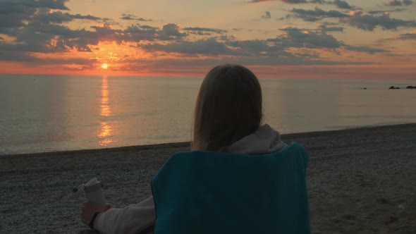 Closeup Shot of Girl Sitting on Camping Chair and Drinking Coffee