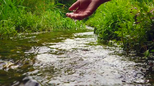 Girl playing with hand in the river.