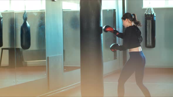 Fit Slim Young Beautiful Brunette Woman Boxing in the Gym