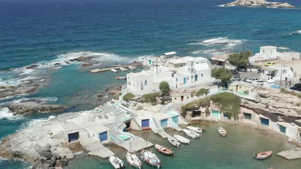 Typical Greek Fishing Village with White Houses and Waves Crashing