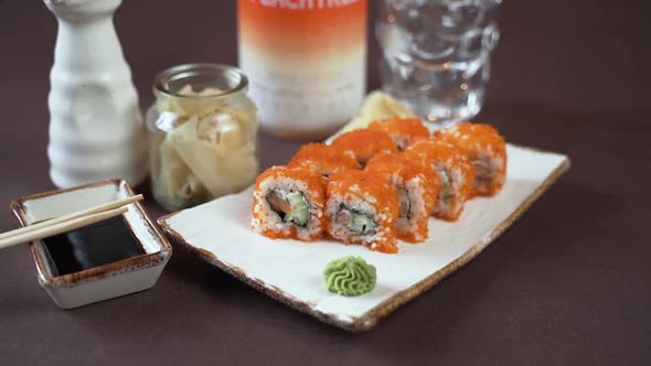 Close-up sushi set with red caviar on a white clay plate