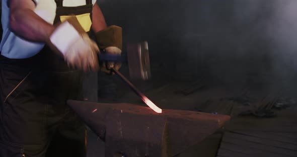 Blacksmith Holding Red Iron Stick By Hands