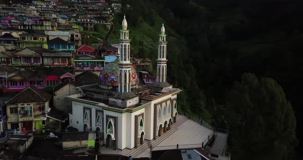 Drone shot of famous Masjid Baituttaqwa Mosque surrounded by green nature and colorful buildings on