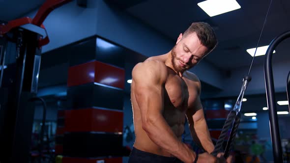 Fitness man pumping up arm muscles.