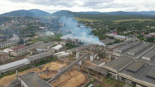 Aerial View of Wood Processing Plant with Smokestack From Production Process Polluting Environment