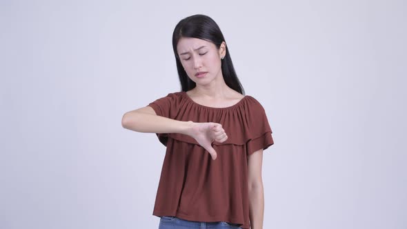 Sad Asian Woman Giving Thumbs Down