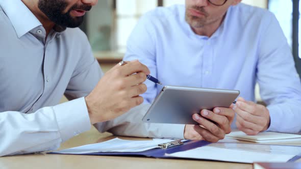 Two Diverse Business Men Analyzing Financial Data Using Digital Tablet