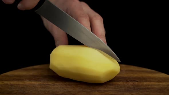 Caucasian man's hands chop potato in kitchen, close up slow motion