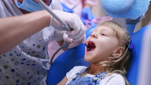Cute girl in dental clinic. Professional dentist working with little girl in clinic