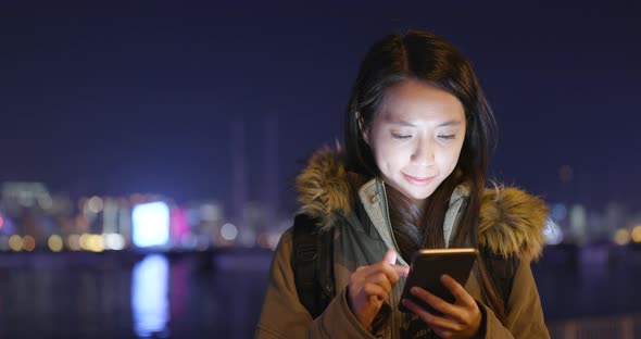 Asian woman use of smart phone in city at night