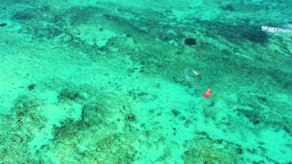 Kitesurfing Le Morne, Mauritius. Drone view flying backwards in front of kite surfer. Kite surfer su