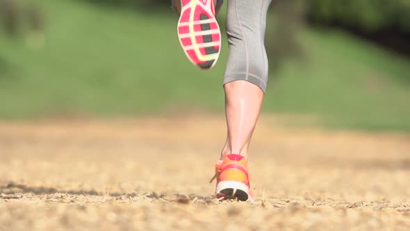 A woman running on a wood chip trail